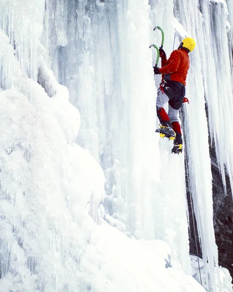 Arrampicata su ghiaccio.Uomo arrampicata cascata congelata . — Foto Stock