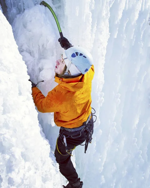 Wspinaczka po lodzie. Człowiek wspinaczka zamarzniętym wodospadzie. — Zdjęcie stockowe