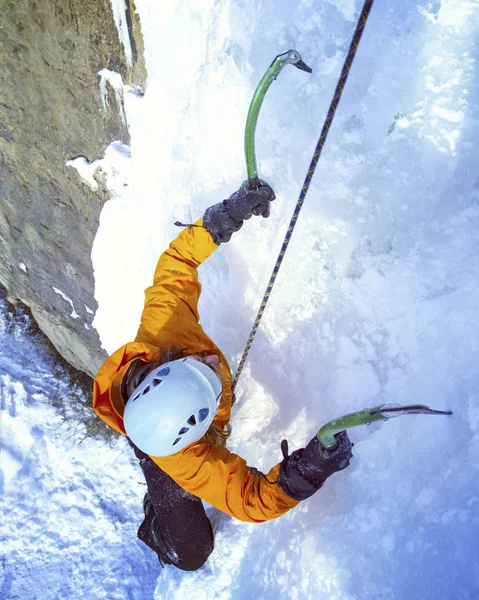 Escalada no Gelo.Homem escalando cachoeira congelada . — Fotografia de Stock