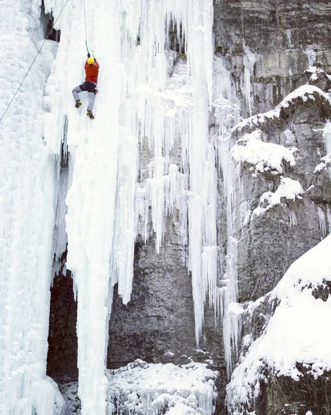 アイス クライミングします。男登山凍った滝. — ストック写真