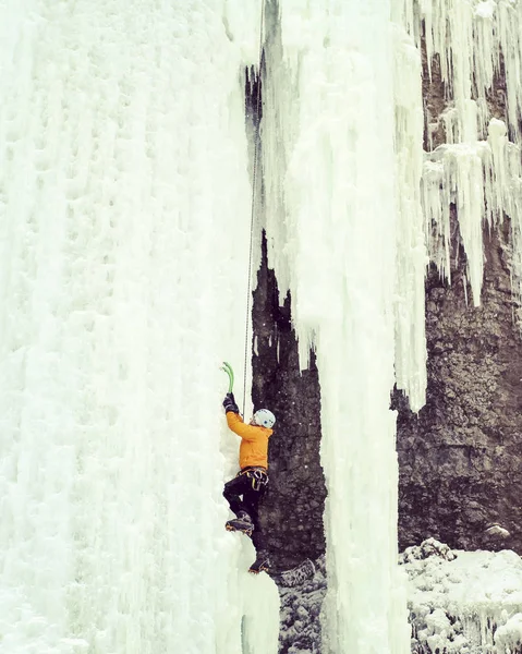 Eisklettern. Mann klettert gefrorenen Wasserfall. — Stockfoto