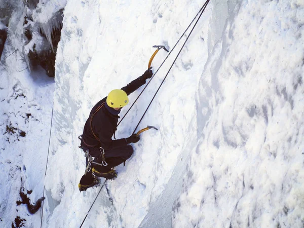 Eisklettern. Mann klettert gefrorenen Wasserfall. — Stockfoto