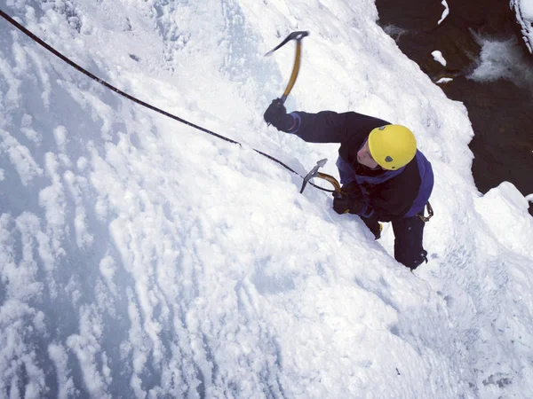 Ice climbing.Man climbing frozen waterfall. — Stock Photo, Image