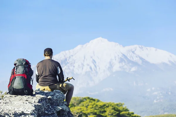 Bir sırt çantası ile Dağları yürüyen adam turizm. — Stok fotoğraf