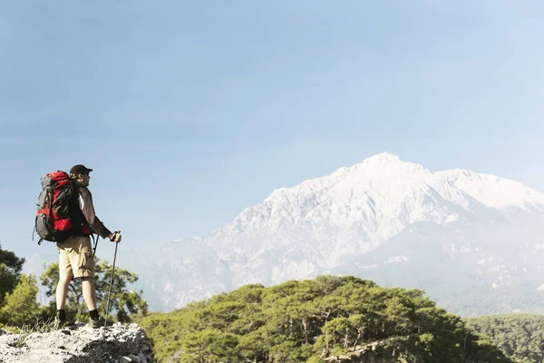 Hombre turista caminando por las montañas con una mochila . — Foto de Stock