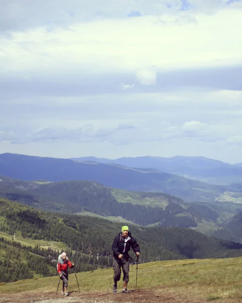 Hombre turista caminando por las montañas con una mochila . — Foto de Stock