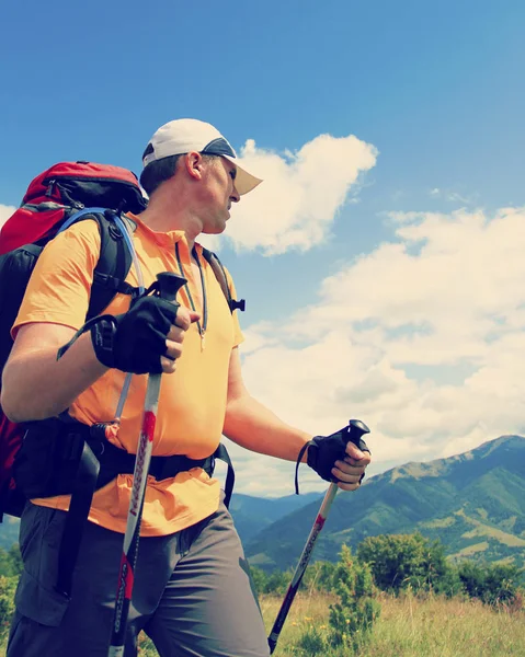 Hombre turista caminando por las montañas con una mochila . — Foto de Stock