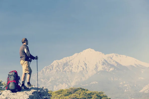 Hombre turista caminando por las montañas con una mochila . — Foto de Stock