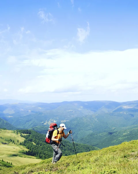 Muž turistické procházky hory s batohem. — Stock fotografie