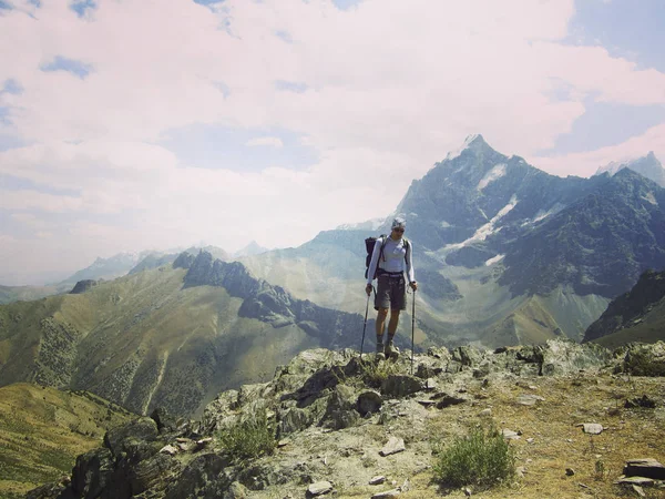 Uomo turista a piedi per le montagne con uno zaino . — Foto Stock