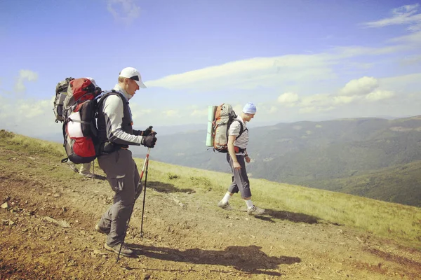 Muž turistické procházky hory s batohem. — Stock fotografie