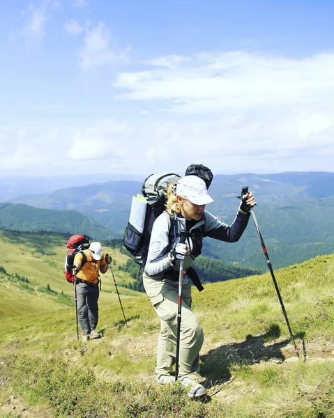 Hombre turista caminando por las montañas con una mochila . — Foto de Stock