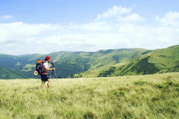 Homem turista caminhando nas montanhas com uma mochila . — Fotografia de Stock