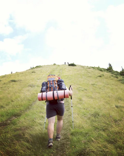 Man toeristische wandelen van de bergen met een rugzak. — Stockfoto