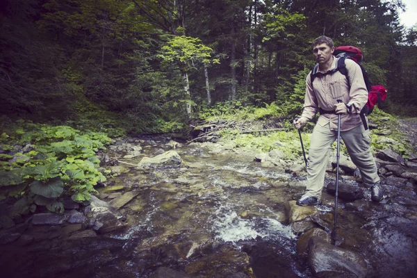 Homme touriste marchant dans les montagnes avec un sac à dos . — Photo