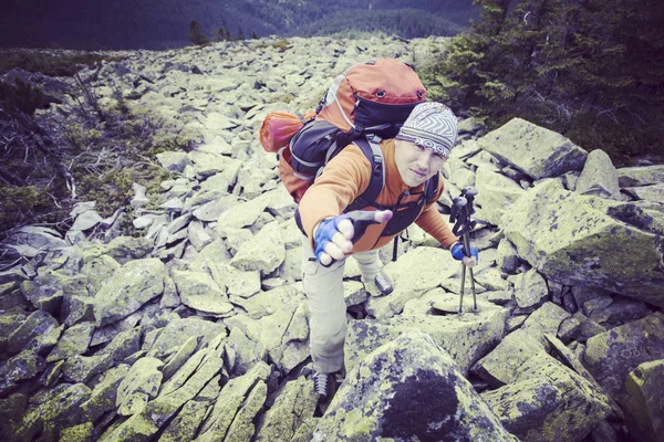 Homem turista caminhando nas montanhas com uma mochila . — Fotografia de Stock