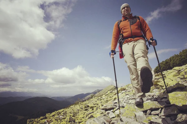 Uomo turista a piedi per le montagne con uno zaino . — Foto Stock