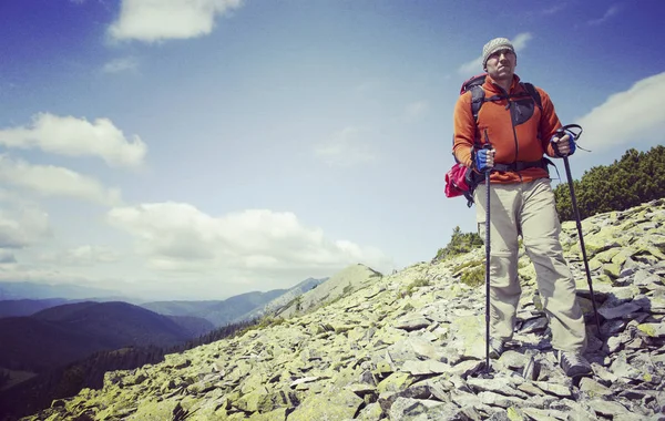 Homem turista caminhando nas montanhas com uma mochila . — Fotografia de Stock