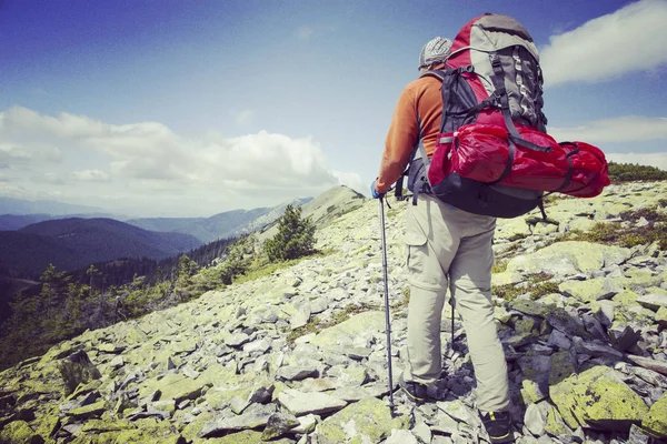 Mann turist går på fjellet med en ryggsekk . – stockfoto