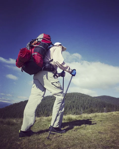 Muž turistické procházky hory s batohem. — Stock fotografie