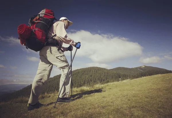 Man toeristische wandelen van de bergen met een rugzak. — Stockfoto