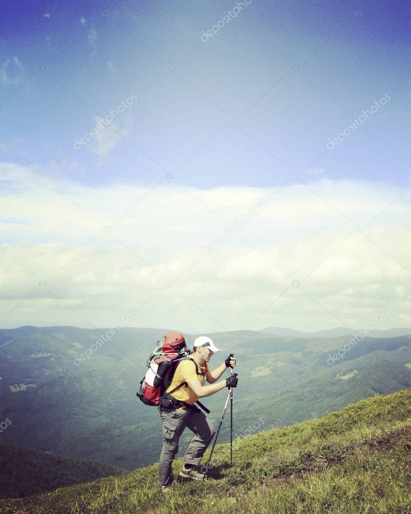 Man tourist walking the mountains with a backpack.