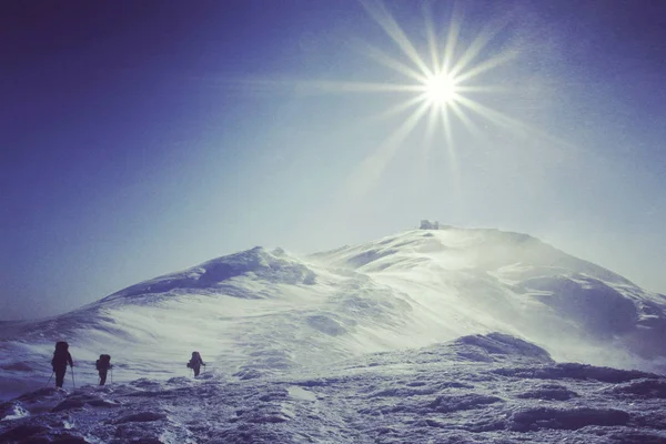 Senderismo de invierno en las montañas en raquetas de nieve con una mochila y —  Fotos de Stock