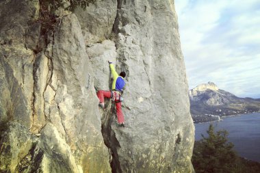 Arka planda geniş Vadisi ile kireçtaşı duvara tırmanma sallamak Climber.Young adam