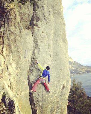Arka planda geniş Vadisi ile kireçtaşı duvara tırmanma sallamak Climber.Young adam