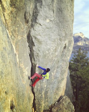Arka planda geniş Vadisi ile kireçtaşı duvara tırmanma sallamak Climber.Young adam