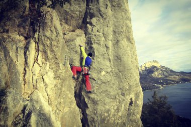 Arka planda geniş Vadisi ile kireçtaşı duvara tırmanma sallamak Climber.Young adam