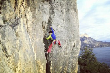 Arka planda geniş Vadisi ile kireçtaşı duvara tırmanma sallamak Climber.Young adam