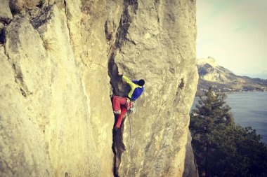 Arka planda geniş Vadisi ile kireçtaşı duvara tırmanma sallamak Climber.Young adam