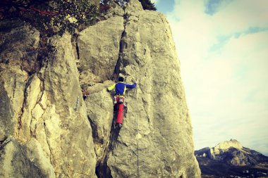 Arka planda geniş Vadisi ile kireçtaşı duvara tırmanma sallamak Climber.Young adam