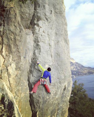 Arka planda geniş Vadisi ile kireçtaşı duvara tırmanma sallamak Climber.Young adam