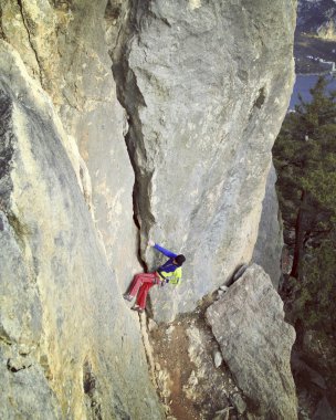 Arka planda geniş Vadisi ile kireçtaşı duvara tırmanma sallamak Climber.Young adam