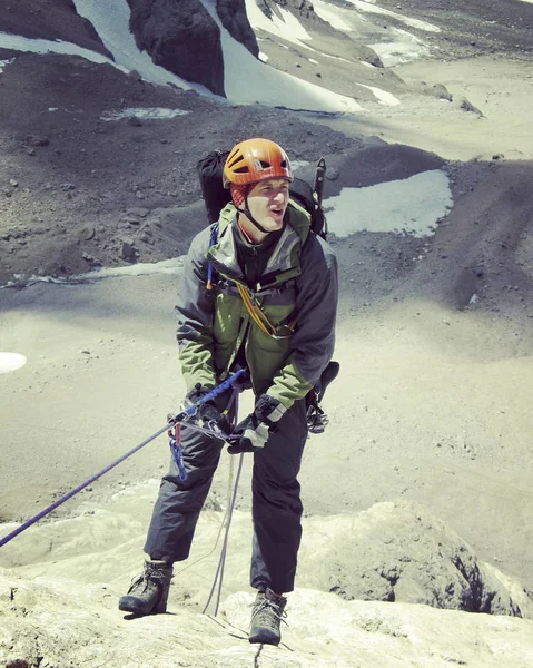 Rock Climber.Young man klimmen op een muur van kalksteen met grote vallei op de achtergrond — Stockfoto