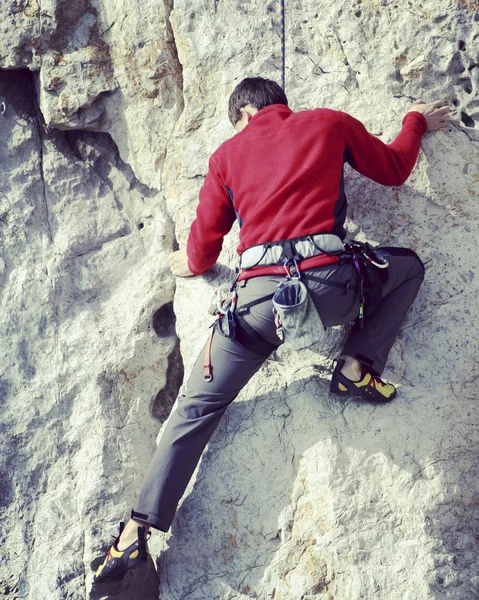 Escalador de rocas.Joven escalando en una pared de piedra caliza con amplio valle en el fondo —  Fotos de Stock