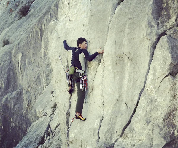 Escalada.Jovem escalando em uma parede de pedra calcária com amplo vale no fundo — Fotografia de Stock