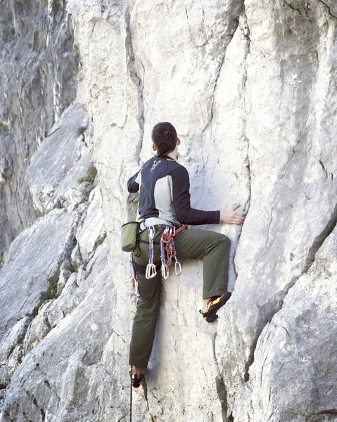 Escalada.Jovem escalando em uma parede de pedra calcária com amplo vale no fundo — Fotografia de Stock