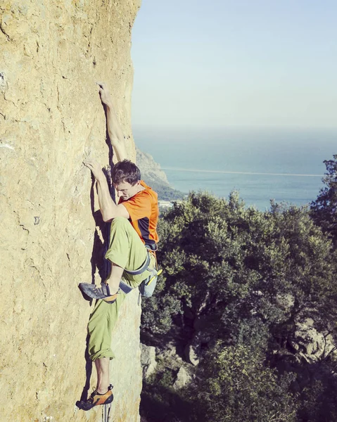 Rock Climber.Young człowiek wspinaczka na ścianie wapienia z szerokiej dolinie na tle — Zdjęcie stockowe