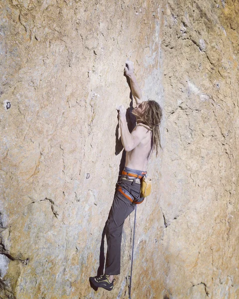 Escalada.Jovem escalando em uma parede de pedra calcária com amplo vale no fundo — Fotografia de Stock
