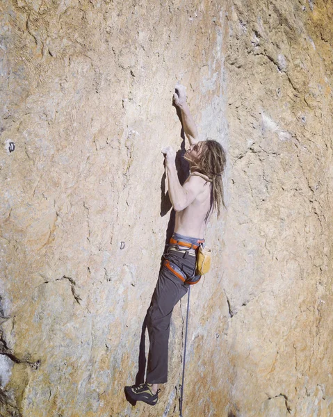 Escalador de rocas.Joven escalando en una pared de piedra caliza con amplio valle en el fondo — Foto de Stock