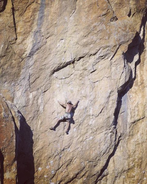 Escalada.Jovem escalando em uma parede de pedra calcária com amplo vale no fundo — Fotografia de Stock