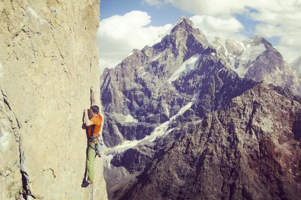 Rock Climber.Young człowiek wspinaczka na ścianie wapienia z szerokiej dolinie na tle — Zdjęcie stockowe