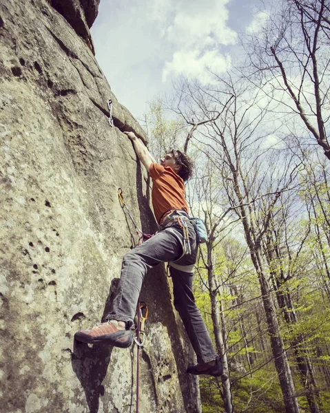 Rock Climber.Young man climbing on a limestone wall with wide valley on the background — Stock Photo, Image