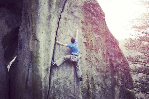 Escalada.Jovem escalando em uma parede de pedra calcária com amplo vale no fundo — Fotografia de Stock