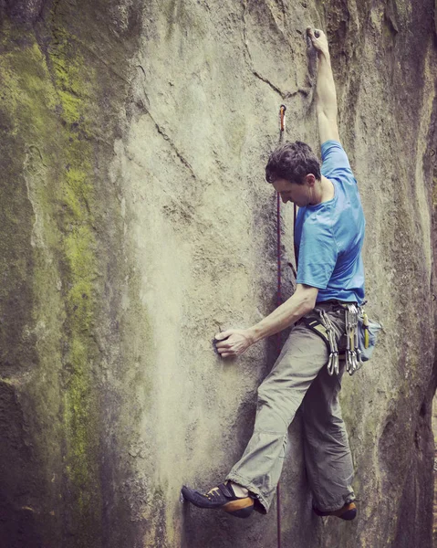 Rock Climber.Young man klimmen op een muur van kalksteen met grote vallei op de achtergrond — Stockfoto