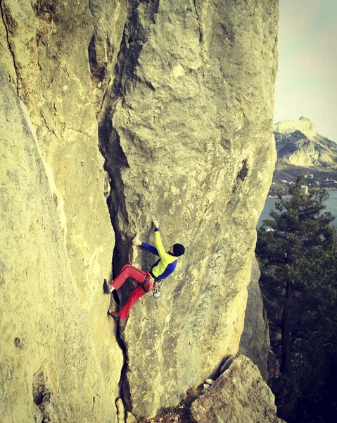 Arrampicata su roccia Giovane arrampicata su una parete calcarea con ampia valle sullo sfondo — Foto Stock