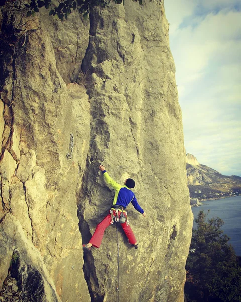 Muž Climber.Young skalní lezení na vápencové zdi s širokým údolím na pozadí — Stock fotografie